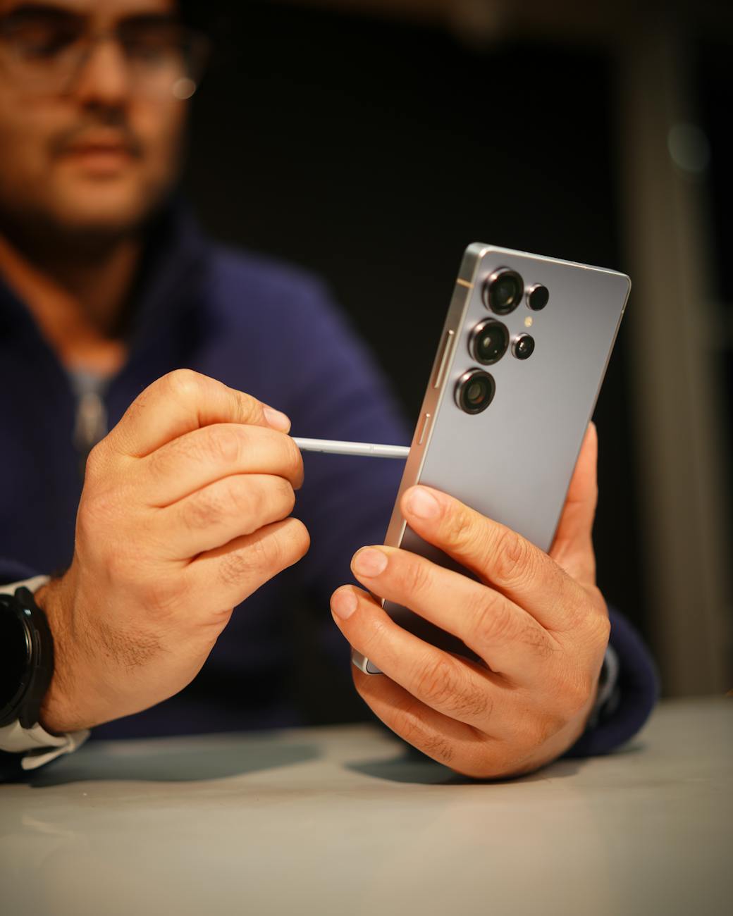 man using stylus on modern smartphone indoors