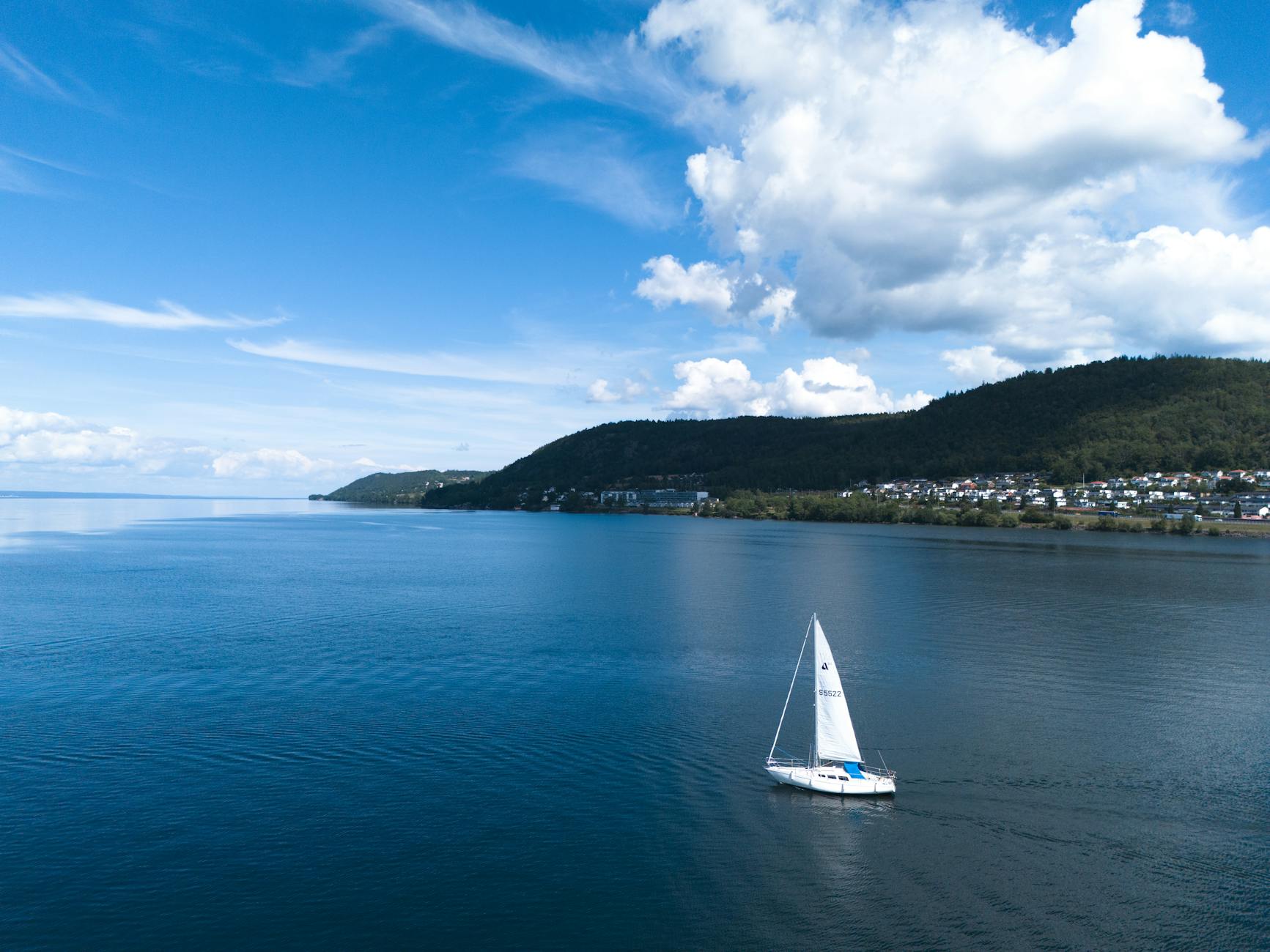 aerial view of sailboat on tranquil blue waters