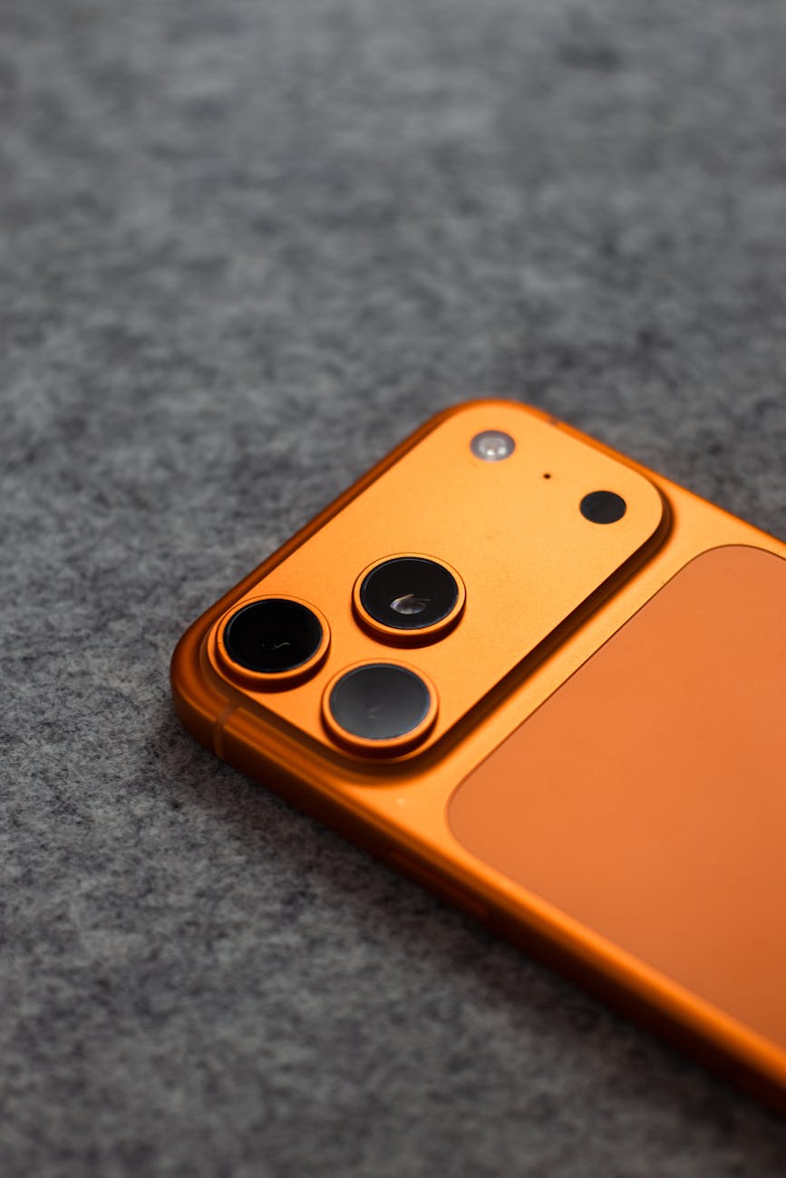 close up of orange smartphone on gray surface